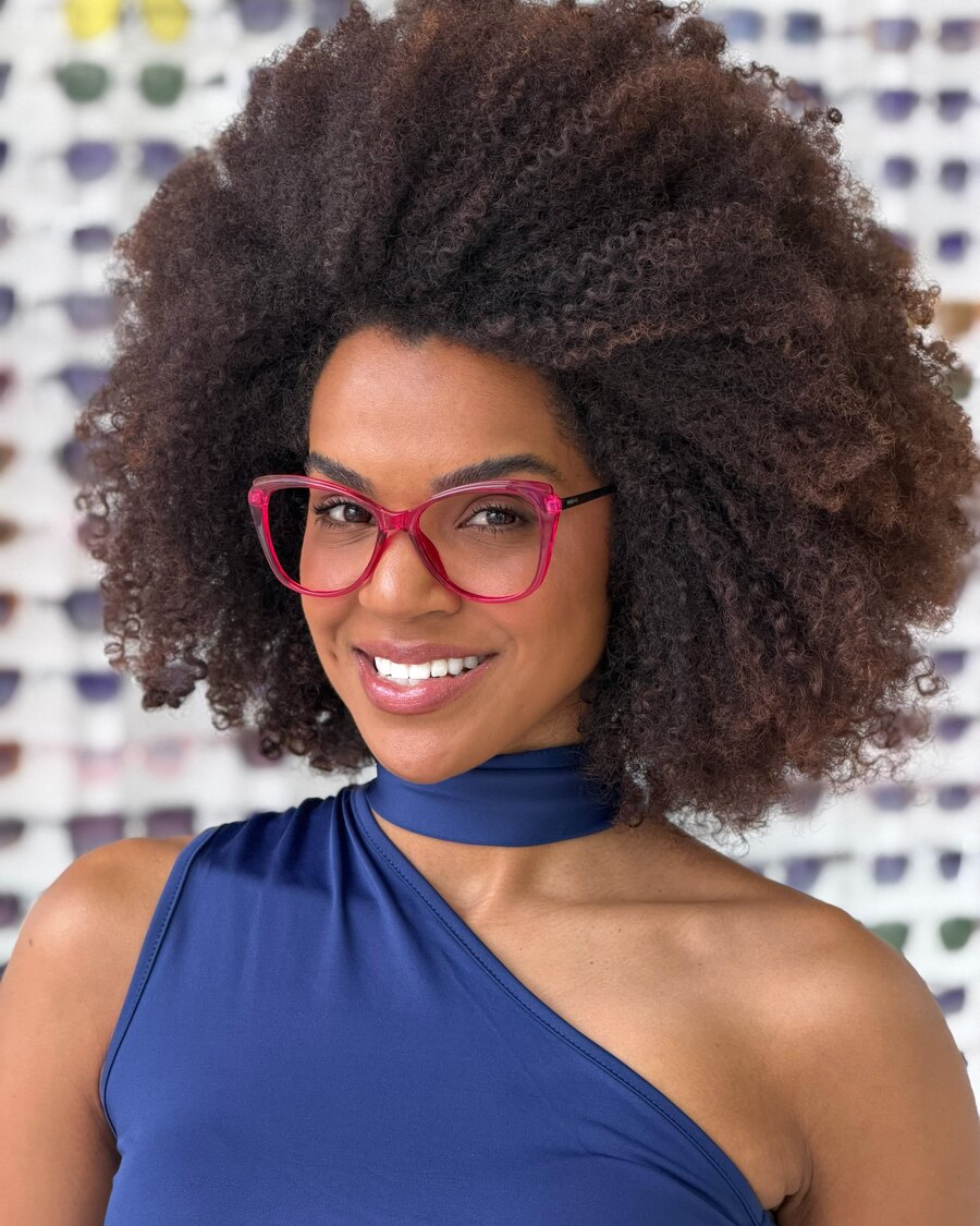 Mulher sorrindo com armação de grau rosa