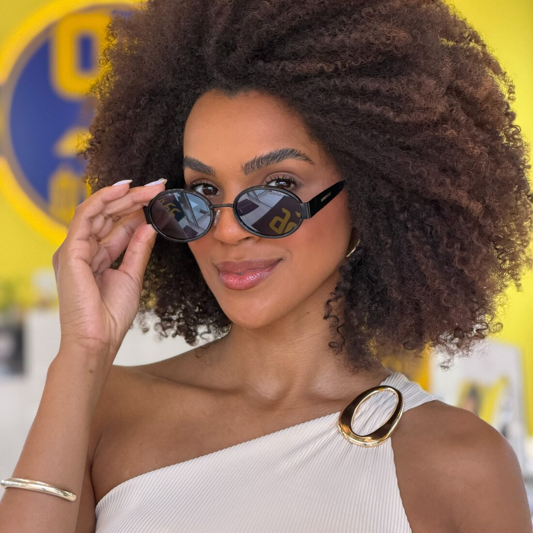 Mulher usando óculos de sol da 99 Óticas