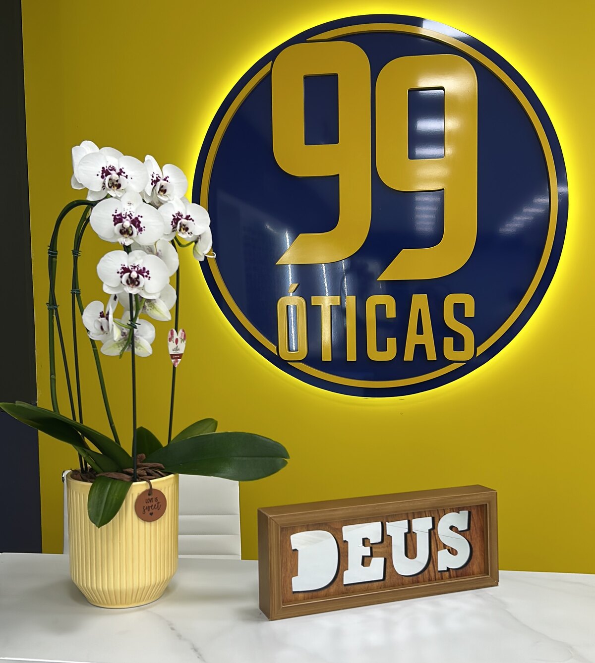 Letreiro da 99 Óticas dentro da loja em Guaíra